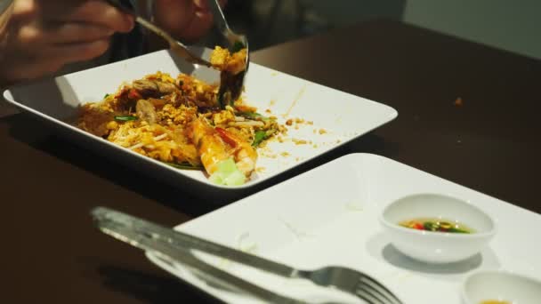 Primer plano. alguien come un plato de cocina asiática en un restaurante . — Vídeos de Stock