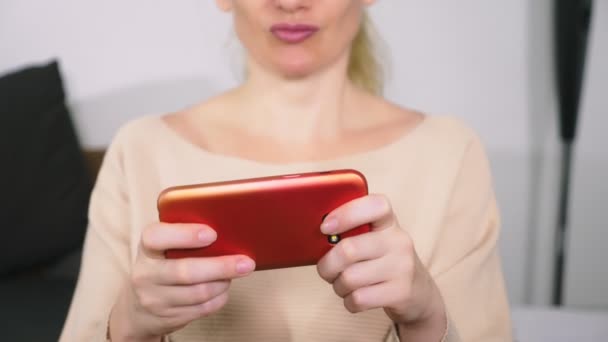 Женщина играет в игры на смартфоне — стоковое видео