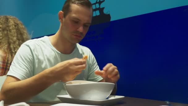 La sopa de camarones es un plato tailandés con un sabor agrio y picante. El hombre se come a Tom Yam en una mesa en un restaurante. Primer plano. concepto de turismo turístico — Vídeo de stock