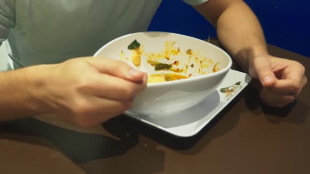 La sopa de camarones es un plato tailandés con un sabor agrio y picante. El hombre se come a Tom Yam en una mesa en un restaurante. Primer plano. concepto de turismo turístico — Vídeos de Stock