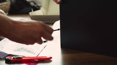 Genç bir adam bağımsız olarak mobilya evinin oturma odasında toplar. Bir adam bilgisayar masası toplar.