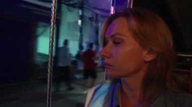 Bir gece sokakta bir tuk tuk içinde güzel yorgun genç kadın sarışın portre. Turizm kavramı