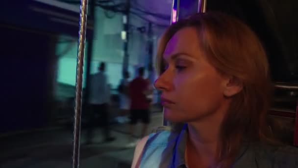 Hermosa mujer joven cansada retrato rubio dentro de un tuk tuk en una calle nocturna. concepto de turismo — Vídeos de Stock