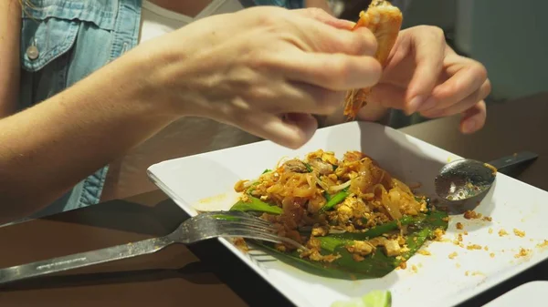 Primer plano. alguien come un plato de cocina asiática en un restaurante . —  Fotos de Stock