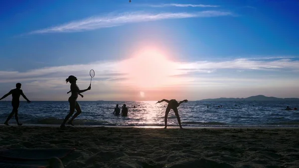 Σιλουέτες. άνθρωποι παίξουμε badminton στην παραλία το ηλιοβασίλεμα. — Φωτογραφία Αρχείου