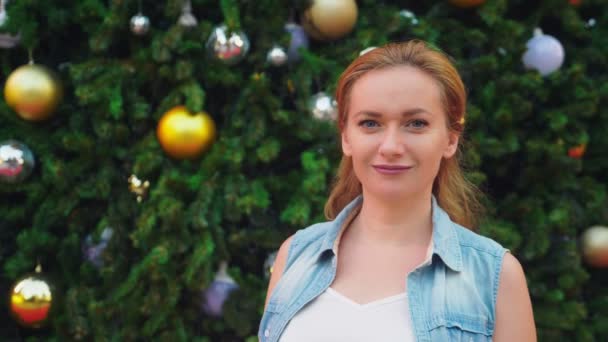 Mujer feliz en el fondo del árbol de Navidad y palmeras en una ciudad tropical. El concepto de Año Nuevo viaja a países cálidos . — Vídeos de Stock