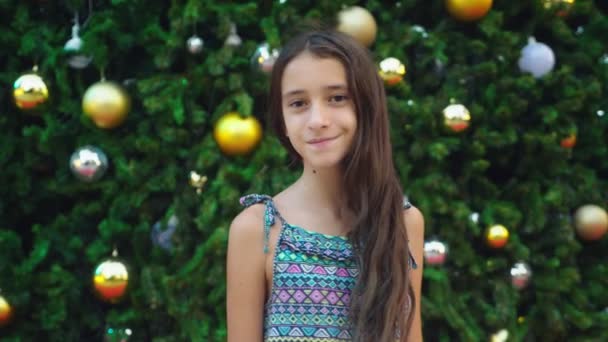 Happy girl on the background of the Christmas tree and palm trees in a tropical city. The concept of New Years travel to warm countries. — Stock Video