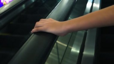 Yürüyen Merdiven Küpeşte kadının el hareketi. 4 k, yavaş hareket, yakın çekim