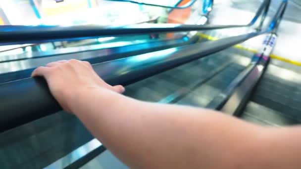 Mouvement de la main des femmes sur les mains courantes de l'escalator. 4k, ralenti, gros plan — Video