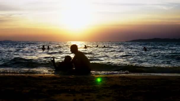 Lekfull stilig kille i shorts gör fitness, på havsstranden mot bakgrund av en underbar solnedgång — Stockvideo