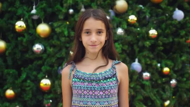 Glad tjej på bakgrunden av julgran och palmer i en tropisk stad. Begreppet nyårs resa till varma länder. — Stockvideo