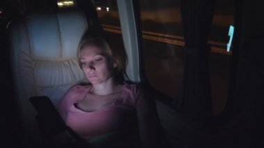 Yorgun bir kadın gece otobüse biner, telefonunu kullanın.