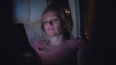 Yorgun bir kadın gece otobüse biner, telefonunu kullanın.