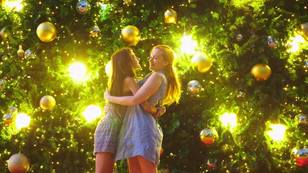 Счастливые мама и дочь на фоне елки в тропическом городе. Концепция новогоднего путешествия в теплые страны . — стоковое фото