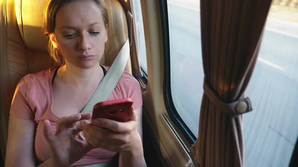 Unavená žena jezdí autobus pomocí telefonu. — Stock fotografie