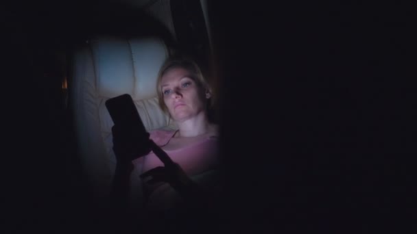 Una mujer cansada monta la noche en el autobús, usa su teléfono . — Vídeo de stock