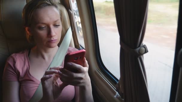 Moe vrouw rijdt de bus met behulp van haar telefoon. — Stockvideo