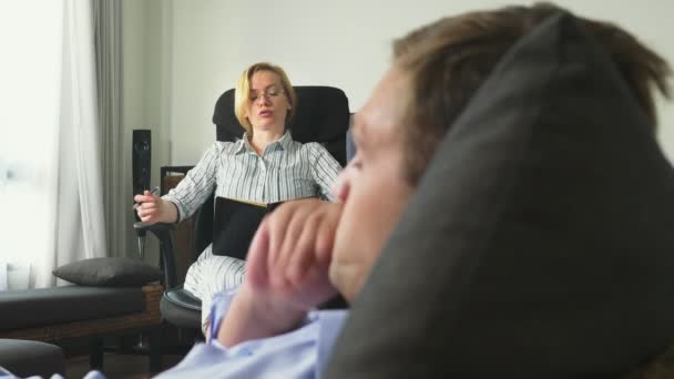 Concetto medico con visita psicologa. psicologa donna dà consulenza psicologica ad un giovane uomo — Video Stock