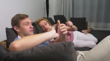 İki kriz. Erkek ve kadın oturma odasında kanepede akşamın. kadın telefonu kullanır, adam ona ödemeyen üzgün.