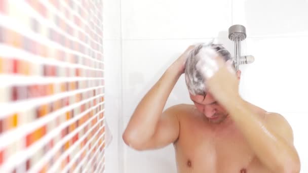 Νεαρός άνδρας πλύσιμο των μαλλιών κάτω από το ντους. Ο άνθρωπος πλένει τα μαλλιά του στο σπίτι. — Αρχείο Βίντεο