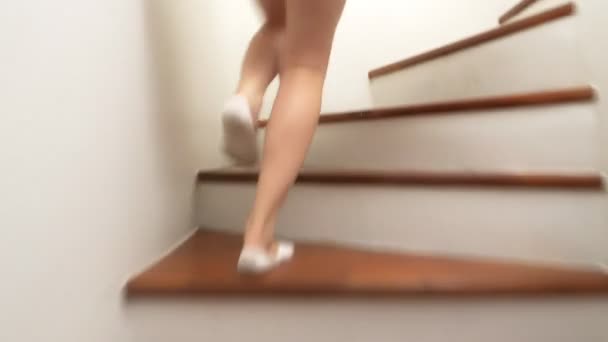 De cerca, las piernas femeninas en calcetines blancos suben las escaleras de madera . — Vídeos de Stock