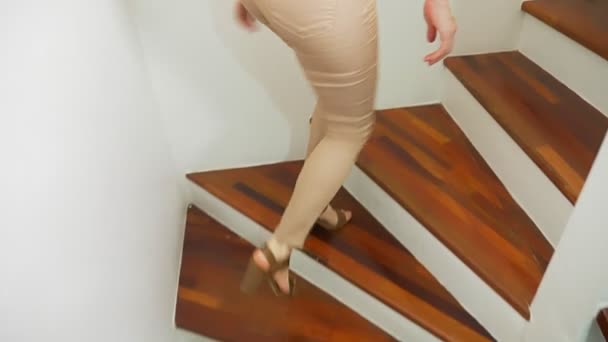 ベージュのタイト フィット パンツとハイヒール サンダルの木製のモダンな階段を歩いてクローズ アップ 女性の足 — ストック動画