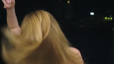 yakın çekim, bir kadın saçları, zemin gece şehrin karşı dokunur. saç sağlık kavramı.