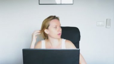 Masada, kızgın ve tahriş olmuş, oturmuş onu laptop kullanan bir kadın yemin ediyor. İnsan duyguları. Internet bağımlılığı kavramı.