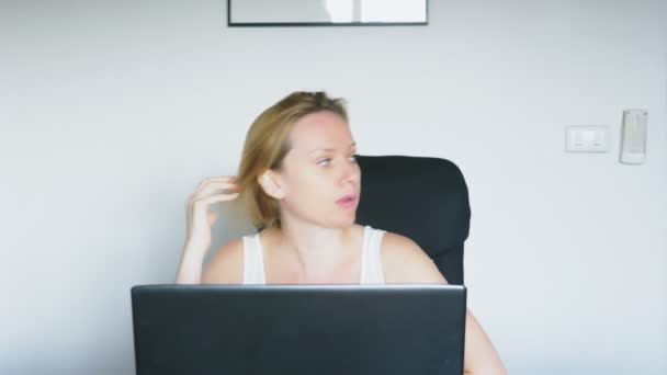 Kobieta za pomocą jej laptopa, siedzi przy stole, zły i podrażnionej, przysięga. Ludzkie emocje. koncepcję uzależnienia od Internetu. — Wideo stockowe