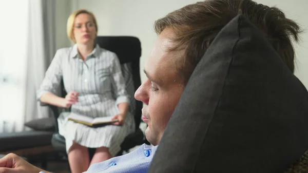 Medische concept met psycholoog bezoek. vrouw psycholoog geeft psychologische counseling aan een jonge man — Stockfoto