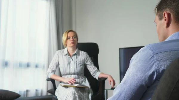 Medische concept met psycholoog bezoek. vrouw psycholoog geeft psychologische counseling aan een jonge man — Stockfoto