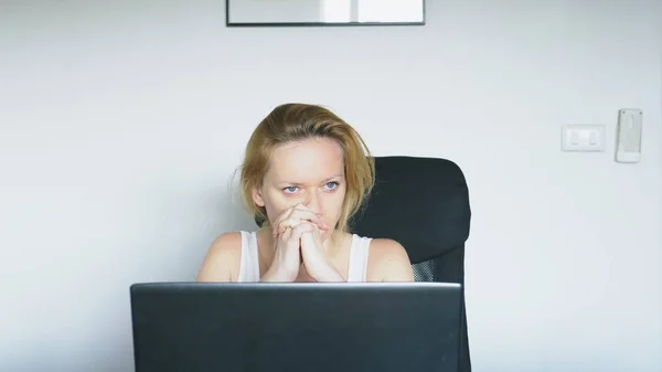 Uma mulher usando um laptop senta-se à mesa, sente desespero e começa a chorar. Emoções humanas. Vício em Internet . — Fotografia de Stock