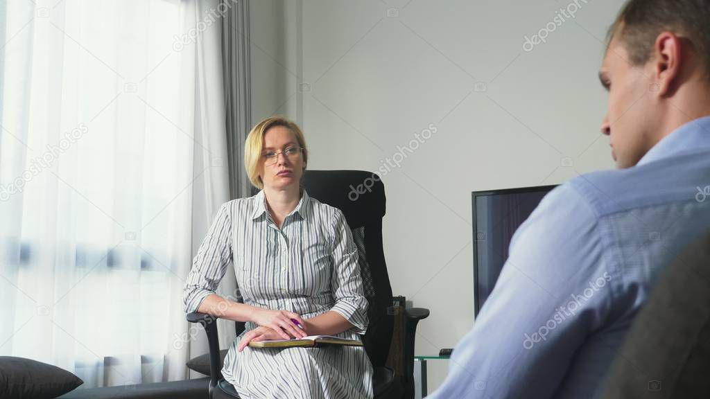 Medical concept with psychologist visit. woman psychologist gives psychological counseling to a young man