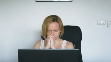 Bir dizüstü bilgisayar kullanan bir kadın masada oturur, hissediyor umutsuzluk ve ağlamaya başlar. İnsan duyguları. Internet bağımlılığı.