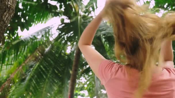 Mooie blonde vrouw raakt haar haren in de natuur. Achteraanzicht. haren behandeling concept — Stockvideo