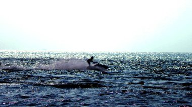 Su sporları. siluet, bir adam bir motosiklet üzerinde denizde yüzen.