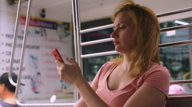 Tayland, Pattaya, Jomtien Beach, 07. 12. 2018. Güzel bir genç kadın bir tuk-tuk öğleden sonra sürmek ve bir akıllı telefon kullanır. Turizm kavramı