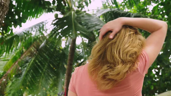 Hermosa mujer rubia toca su cabello en la naturaleza. Vista trasera. concepto de tratamiento capilar — Foto de Stock