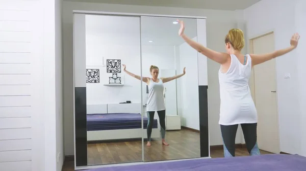 Femme s'étirant près du miroir à son appartement. Le concept d'un mode de vie sain, pas un sport professionnel . — Photo