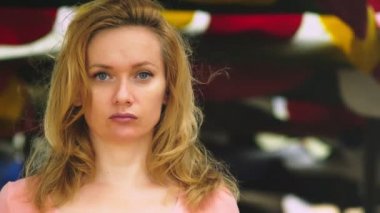 Sarı saçlı güzel bir genç kadınla dikkatle kameraya bakarak rüzgarlı bir günde notunuzda boş duruyor. kopya alanı