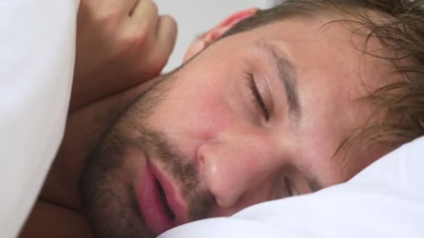 Chory młody człowiek z gorączką śpi w łóżku, objęte koc — Wideo stockowe