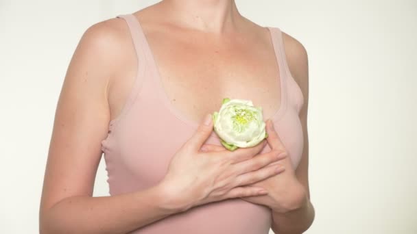 Close-up. female breast closeup with lotus flower in her hands. female breast health concept — Stock Video