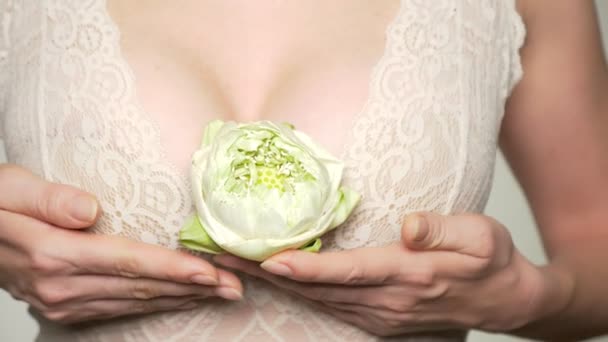 Close-up. female breast closeup with lotus flower in her hands. female breast health concept — Stock Video