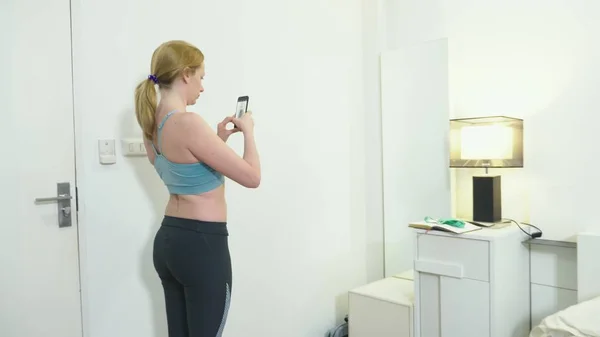 O conceito de sobrepeso e perda de peso. Uma mulher olha-se ao espelho e fotografa a sua figura. comparar os resultados antes e depois da perda de peso . — Fotografia de Stock