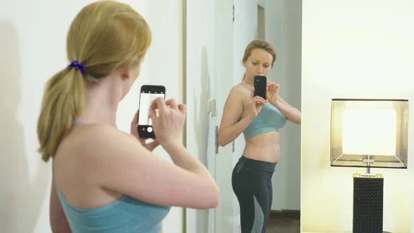 Fazla kilolu ve kilo kaybı kavramı. Bir kadın kendini aynaya bakar ve onu rakam fotoğraflar. daha önce ve kilo kaybettikten sonra sonuçları karşılaştırmak için. — Stok fotoğraf