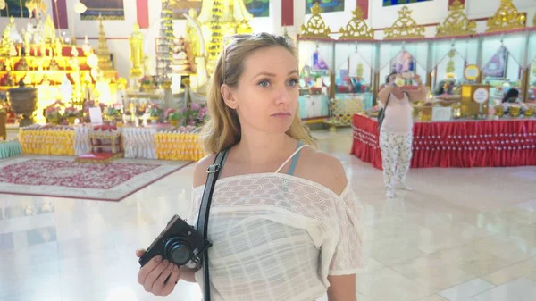 एशिया में पर्यटन की अवधारणा। यूरोपीय महिला एक बौद्ध मंदिर में दर्शनीय स्थलों को देखते हुए सफेद बाल और नीली आंखों के साथ पर्यटक . — स्टॉक फ़ोटो, इमेज
