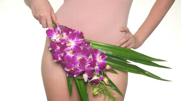 Mulher segurando uma flor no fundo da roupa interior, o conceito de saúde feminina e cuidados com o corpo — Fotografia de Stock