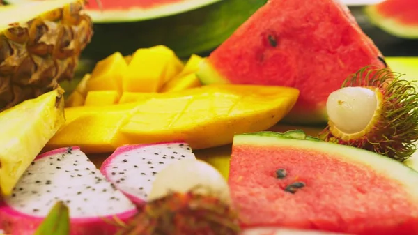 Frutas tropicales mixtas, primer plano. fruta fresca en rodajas. antecedentes . — Foto de Stock