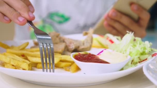 Birisi Fast food, kızarmış gevrek ve baharatlı şeritler ve tuz ve ketçap soslu patates kızartması yiyor. Yukarıdan görüntülemek. — Stok video
