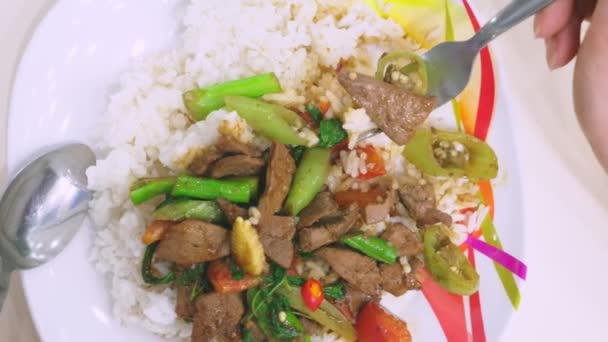 Alguien come con un tenedor, arroz con hígado, comida vista superior en un plato blanco . — Vídeos de Stock